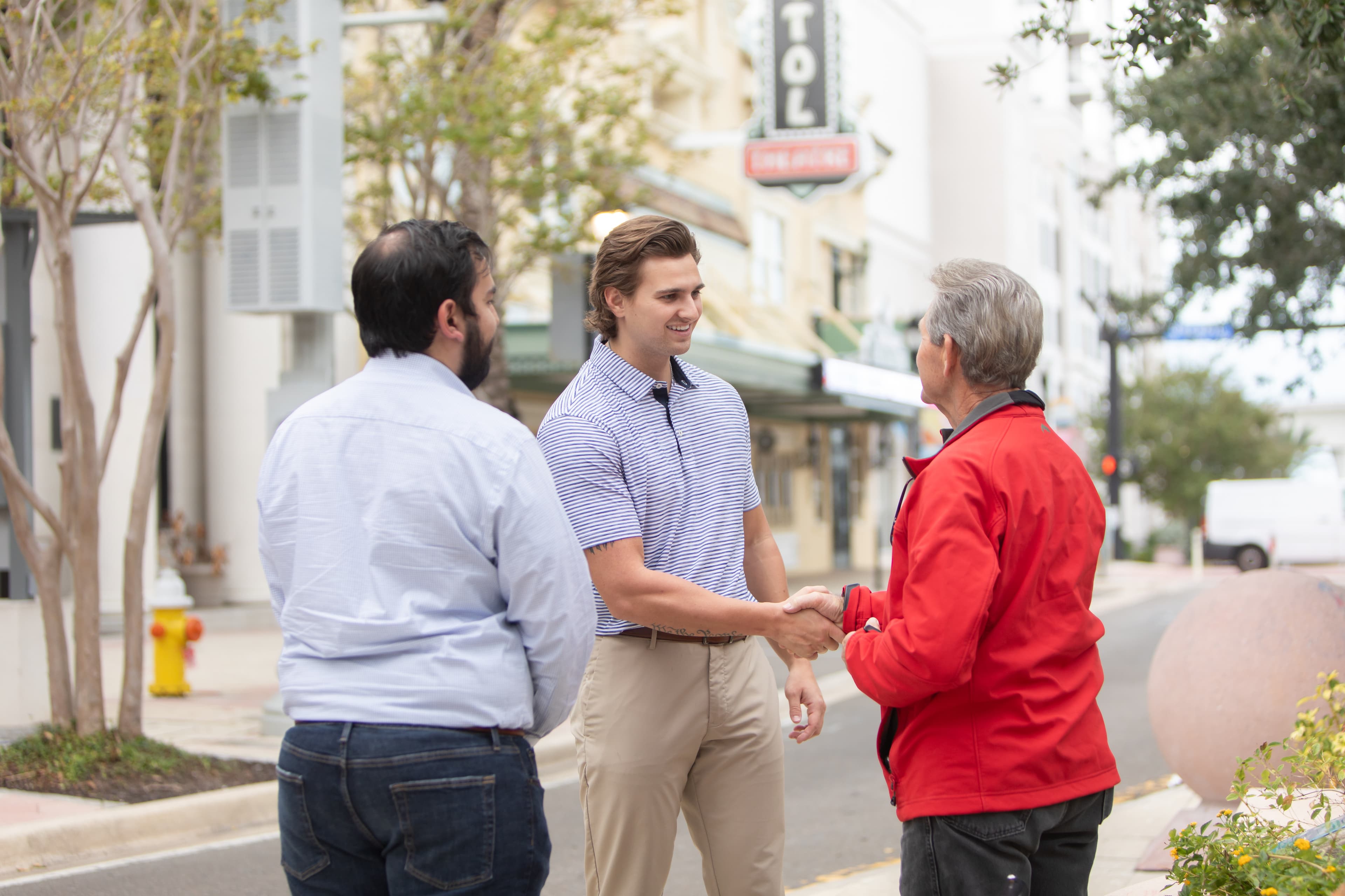 Sam Wilson shaking hands with community members on a downtown Clearwater street